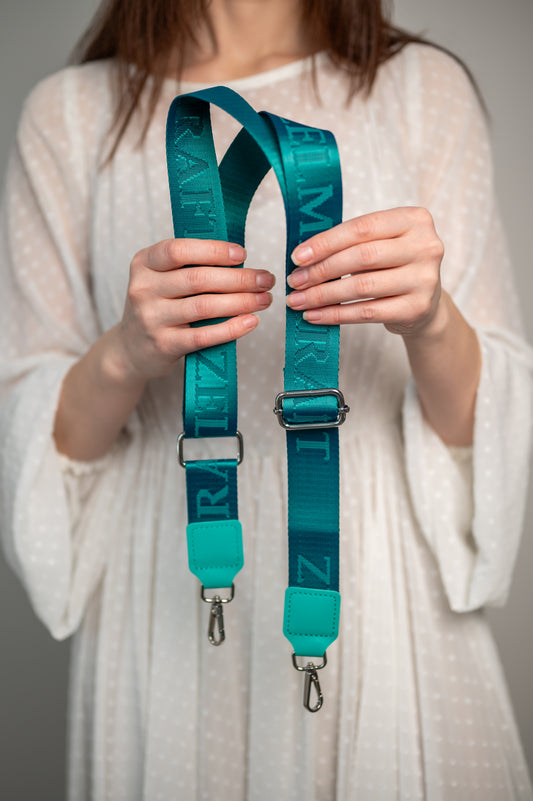 Plecu siksna ar logotipu Zilganzaļa